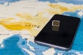 Micro SIM card and smartphone on the world map Royalty Free Stock Photo