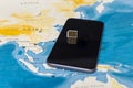 Micro SIM card and smartphone on the world map Royalty Free Stock Photo
