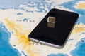 Micro SIM card and smartphone on the world map Royalty Free Stock Photo