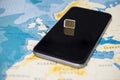 Micro SIM card and smartphone on the world map Royalty Free Stock Photo