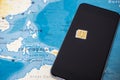 Micro SIM card and smartphone on the world map Royalty Free Stock Photo