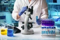 Microbiologist scientist analyzing a sample under a microscope in the science lab Royalty Free Stock Photo