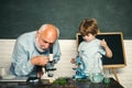 Microbiology science. Little kids scientist earning Biology in school lab. School concept. Chalkboard copy space.