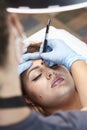 Microblading, woman drawing with pencil eyebrow shape. elevated view,