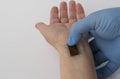 Microchip is connected to a man hand. implantation of a chip under the human skin