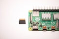 Microcomputer Raspberry Pi 4 with a microsd card lying next to it, ready to use for its intended purpose