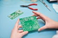 Microcontroller circuit board manufacture. Technician`s hand with pcb Royalty Free Stock Photo