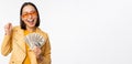 Microcredit and money concept. Stylish asian young woman in sunglasses, laughing happy, holding dollars cash, standing Royalty Free Stock Photo