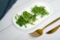 Microgreens sunflower and alfalfa with cutlery on the table. Healthy vitamins food concept.