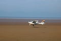 Microlight plane taking off from beach, Knott End