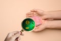 Microorganisms research. Women with magnifying glass and paper intestine cutout on beige background, closeup