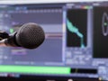 Microphone on the background of the computer monitor. Home recording Studio. Close-up. The focus in the foreground