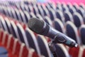 Microphone on the background of rows of chairs in the hall