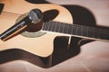 microphone and brown acoustic guitar on wood background