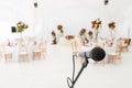 Microphone close-up. Focus on mic. Abstract blurred conference hall or wedding banquet on background. Event concept Royalty Free Stock Photo