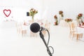 Microphone close-up. Focus on mic. Abstract blurred conference hall or wedding banquet on background. Event concept Royalty Free Stock Photo