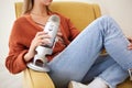 Microphone, closeup and woman hosting a podcast on a chair by a wall in her modern home. Radio, broadcast and young