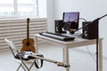 Microphone, computer and musical equipment guitars and piano background. Home recording studio concept. Royalty Free Stock Photo