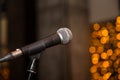 Microphone in concert hall or conference room with defocused bokeh lights in background. Royalty Free Stock Photo