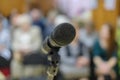 Microphone in concert hall or conference room with defocused bokeh lights in background. Extremely shallow dof Royalty Free Stock Photo