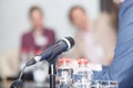 Microphone in focus against blurred people at roundtable event Royalty Free Stock Photo