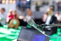 Microphone in focus, blurred audience in the background Royalty Free Stock Photo