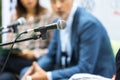 Public speaking concept. Microphone in focus at roundtable meeting or business event. Royalty Free Stock Photo