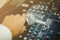 Microphone in hand and adjust an audio mixer controller in the c Royalty Free Stock Photo