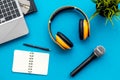 Microphone, headphones, notebook and laptop for blogger, journalist or musician work on blue background top view mock-up Royalty Free Stock Photo