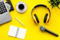 Microphone, headphones, notebook and laptop for blogger, journalist or musician work on yellow background top view mock