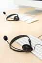 Microphone headsets on the table with computer keyboards in call Royalty Free Stock Photo