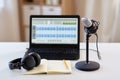 Microphone, laptop, headphones, notebook on table