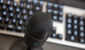 Microphone, mike condenser black metallic, blur keypad background Royalty Free Stock Photo