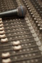 Microphone on old dirty sound mixer pult. Royalty Free Stock Photo