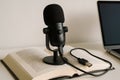 Microphone on an open book next to a laptop for recording audio projects Royalty Free Stock Photo