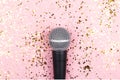 A microphone on pink background decorated with confetti. Minimal compostion. Royalty Free Stock Photo