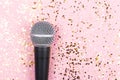 A microphone on pink background decorated with confetti. Minimal compostion Royalty Free Stock Photo