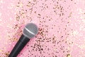 A microphone on pink background decorated with confetti. Minimal compostion Royalty Free Stock Photo