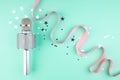 Microphone with a pink ribbon on a green background with confetti. Royalty Free Stock Photo
