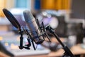 Microphone in a professional recording or radio studio, equipment in the blurry background Royalty Free Stock Photo