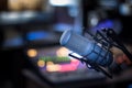 Microphone in a professional recording or radio studio, equipment in the blurry background Royalty Free Stock Photo