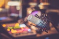 Microphone in a professional recording or radio studio, equipment in the blurry background Royalty Free Stock Photo