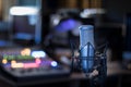 Microphone in a professional recording or radio studio, equipment in the blurry background Royalty Free Stock Photo