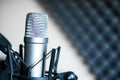 Microphone in a professional recording or radio studio, sound insulation in the blurry background Royalty Free Stock Photo