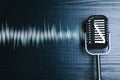 Microphone with radio wave on wooden background