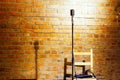 Microphone ready on stage against a brick wall ready for the Karaoke performer Royalty Free Stock Photo