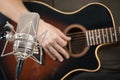 Microphone recording an acoustic guitar played by hand