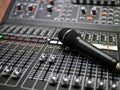 Microphone rests on an audio mixer controller in the control room, Sound mixer control for live music and studio equipment, music Royalty Free Stock Photo