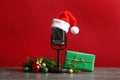 Microphone with Santa hat and decorations on grey table. Christmas music