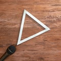 Microphone and silver triangular frame on wooden background. Text space. Top view. Minimal style Royalty Free Stock Photo